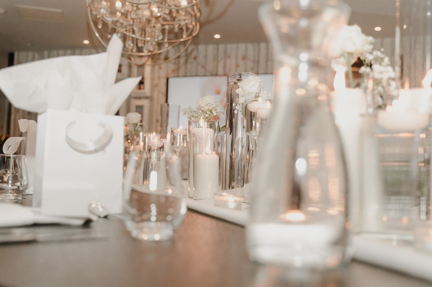 Candlelit tablescape with white roses and glass vases